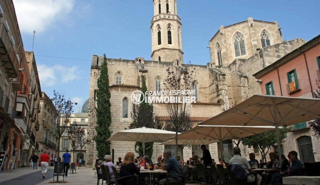 un vistazo a la iglesia de saint pere y a las terrazas de los restaurantes cercanos