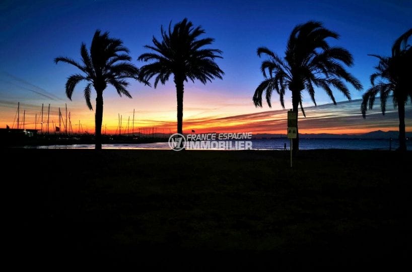 coucher de soleil sur la baie de roses, palmiers plage et mer
