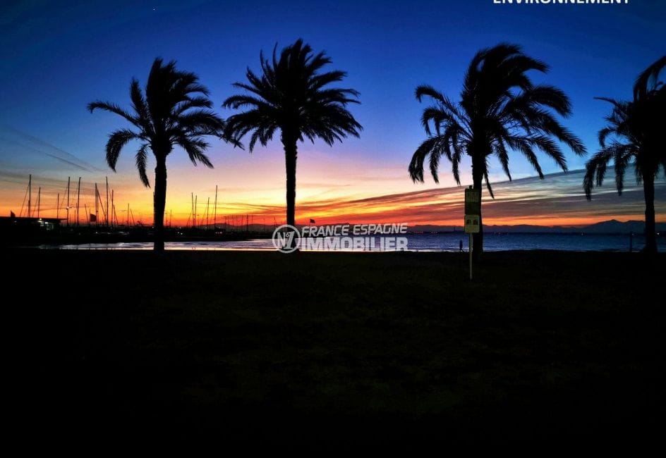 coucher de soleil sur la baie de roses, palmiers plage et mer