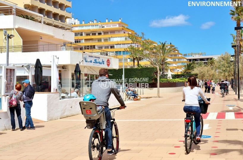 promenade en vélo le long de la plage de rosas avec ses boutiques et restaurants